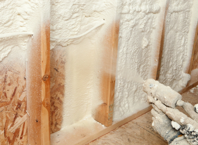 ongoing sprayfoaming insulation applied to the wall